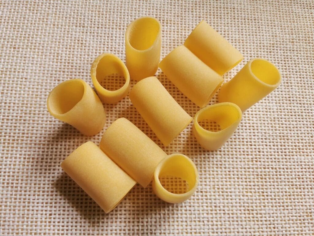 uncooked dried paccheri tubes on white cloth