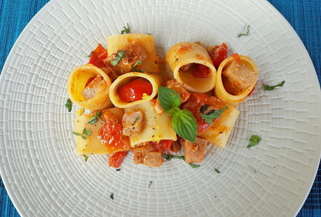 Mezzi paccheri with fresh tuna ragu on white plate