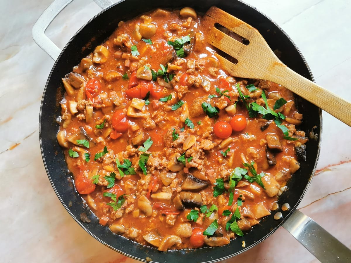 Ready boscaiola sausage and mushroom sauce in skillet and sprinkled with chopped fresh parsley.