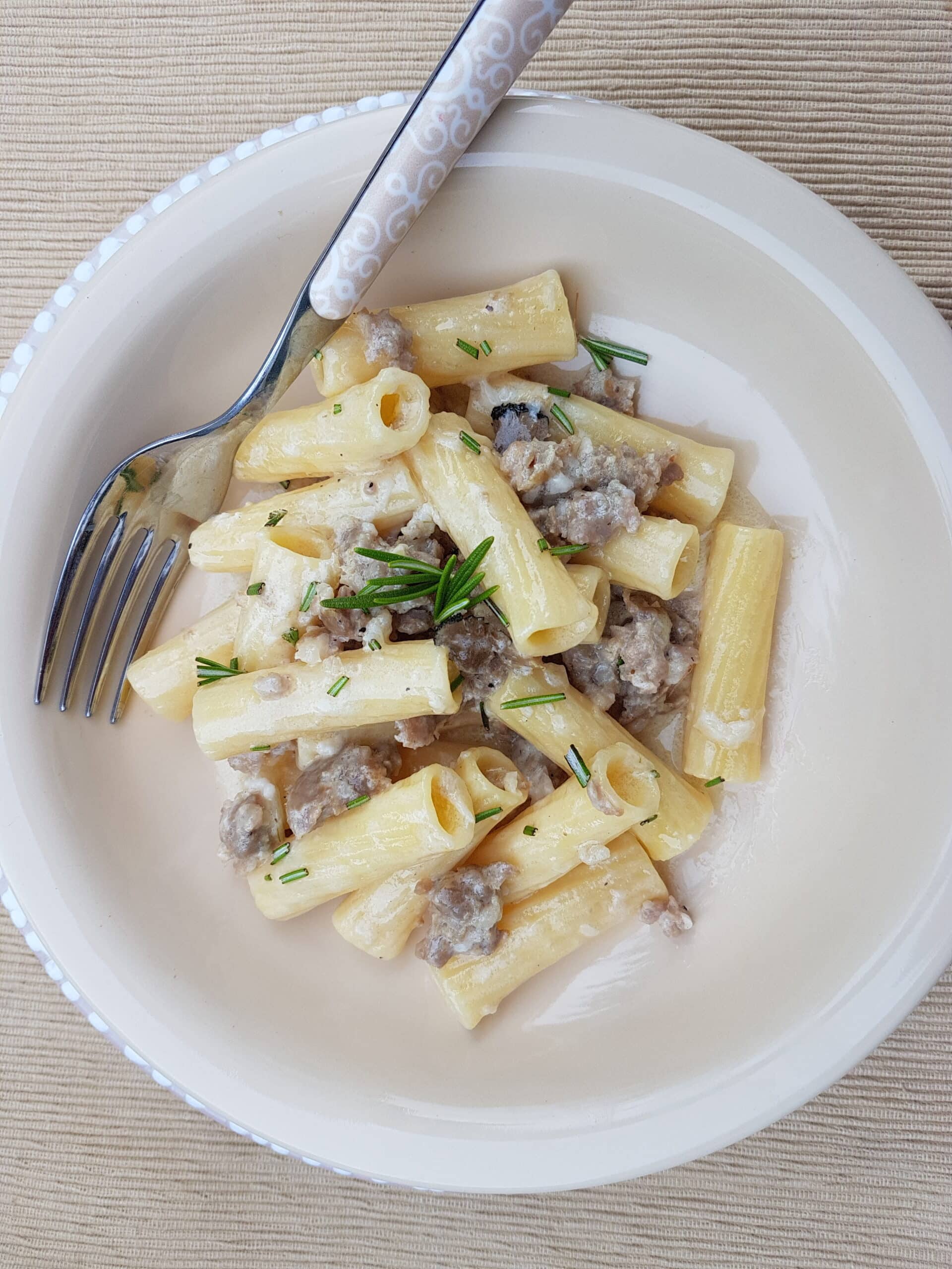 Pasta alla norcina garnished with rosemary.