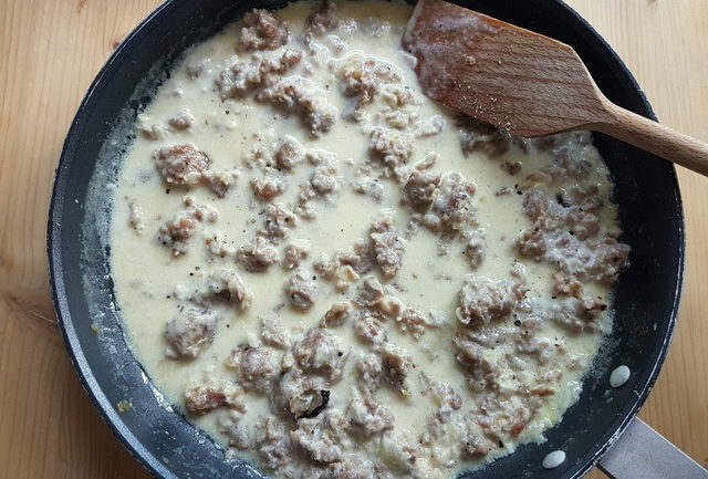 sausage meat and cream pasta sauce cooking in frying pan