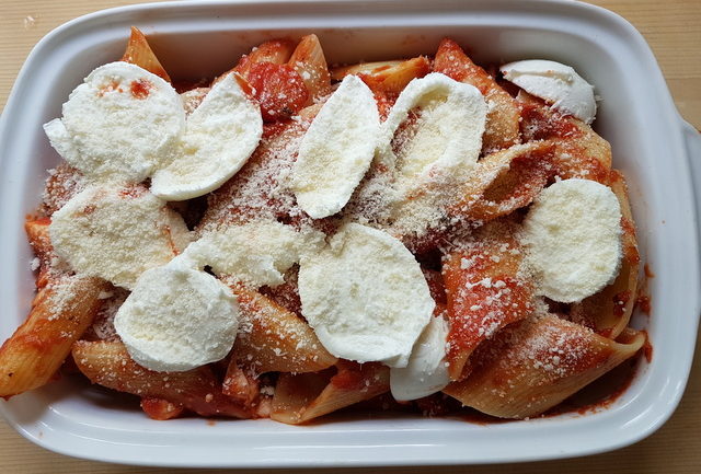 pennoni alla pizzaiola in oven dish with mozzarella slices