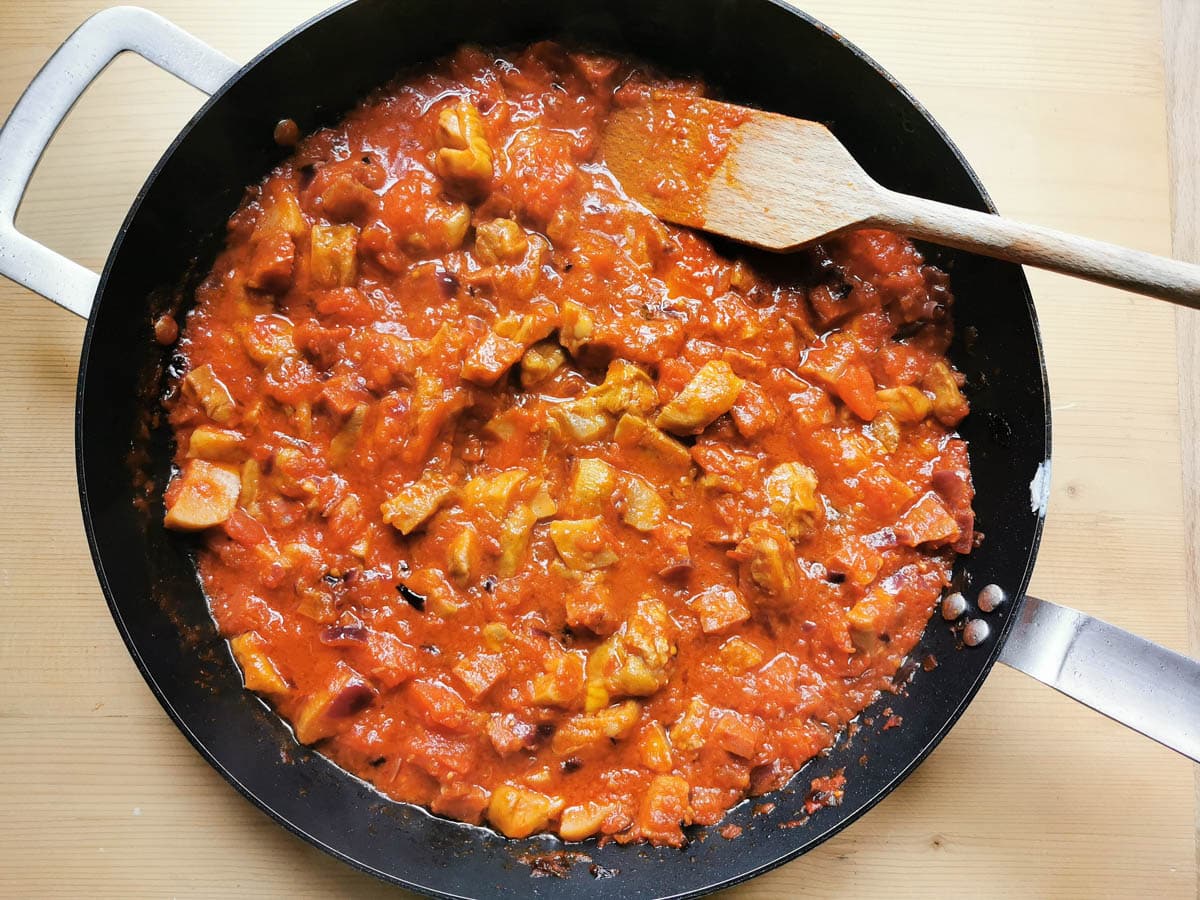 Spicy sausage sauce being reduced in a pan.