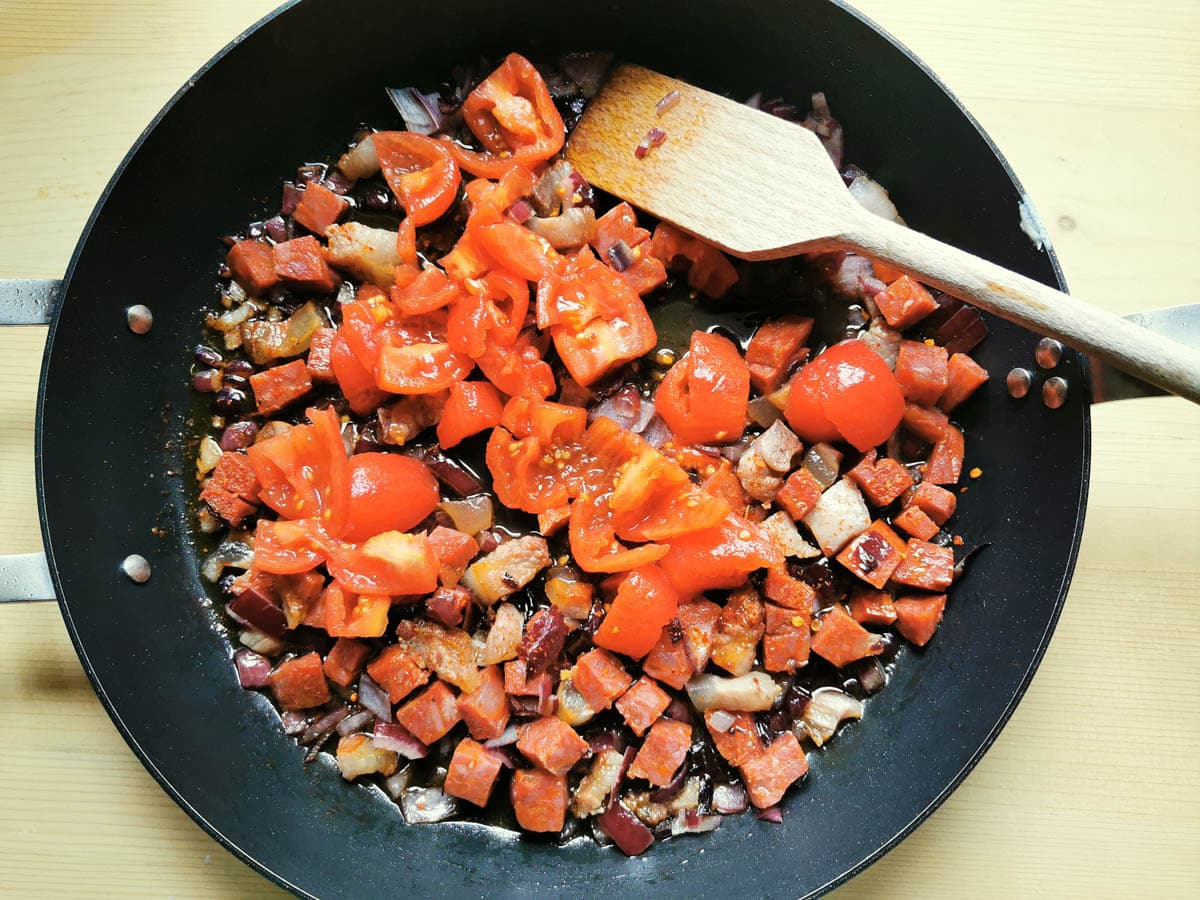 Chopped fresh tomatoes added to the pan.