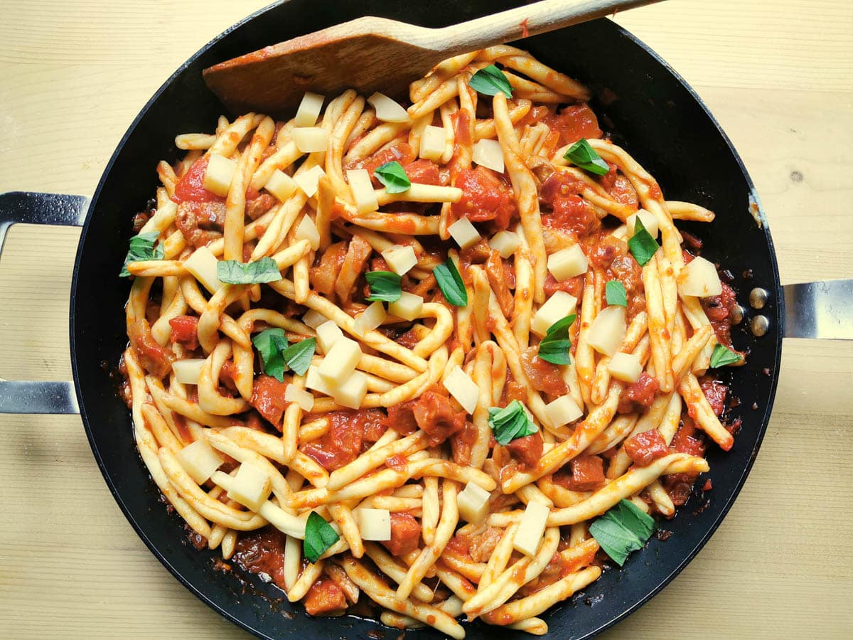 Italian spicy sausage pasta with fresh basil.