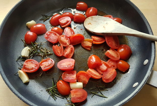 garlic, rosemary and cherry tomatoes in frying pan