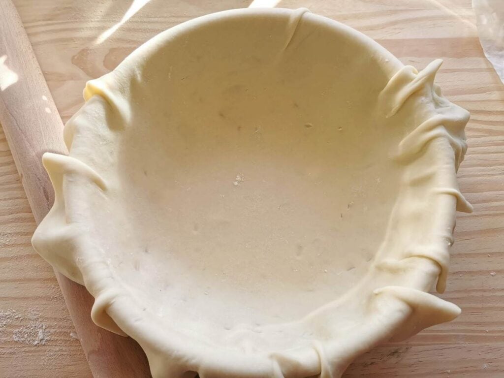 sheet of shrotcrust pastry dough in round oven dish