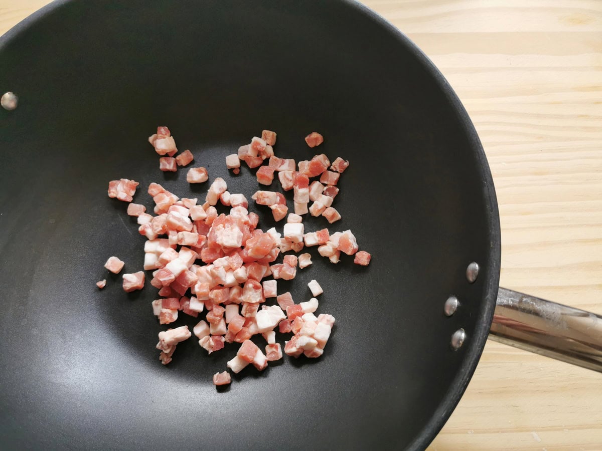 Pancetta cubes in dee frying pan.