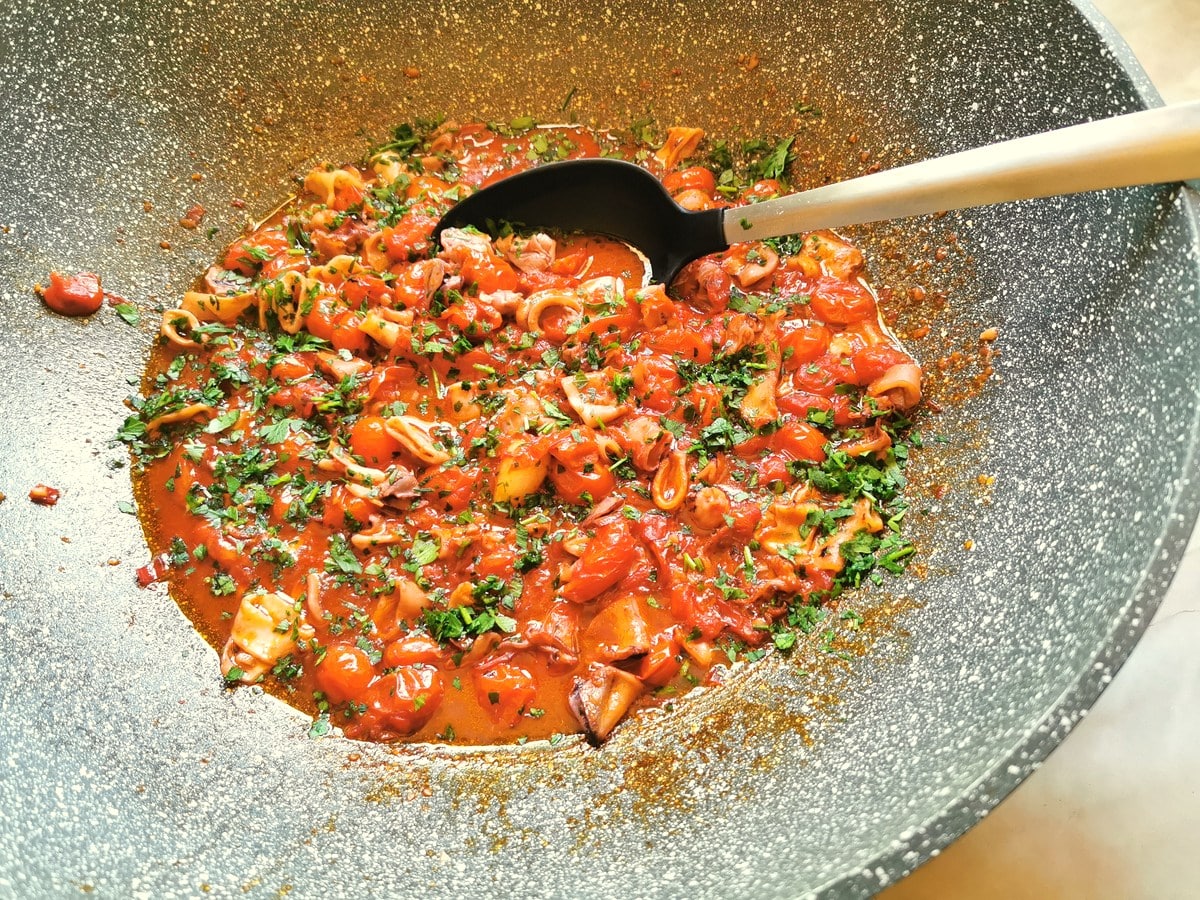 Calamari sauce in a pan with parsley added