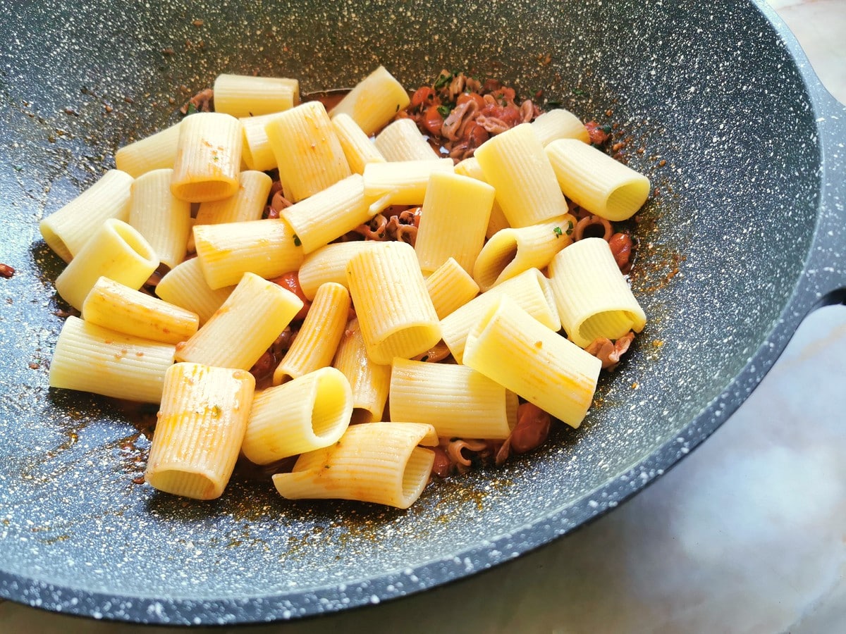 Adding pasta to the calamari sauce