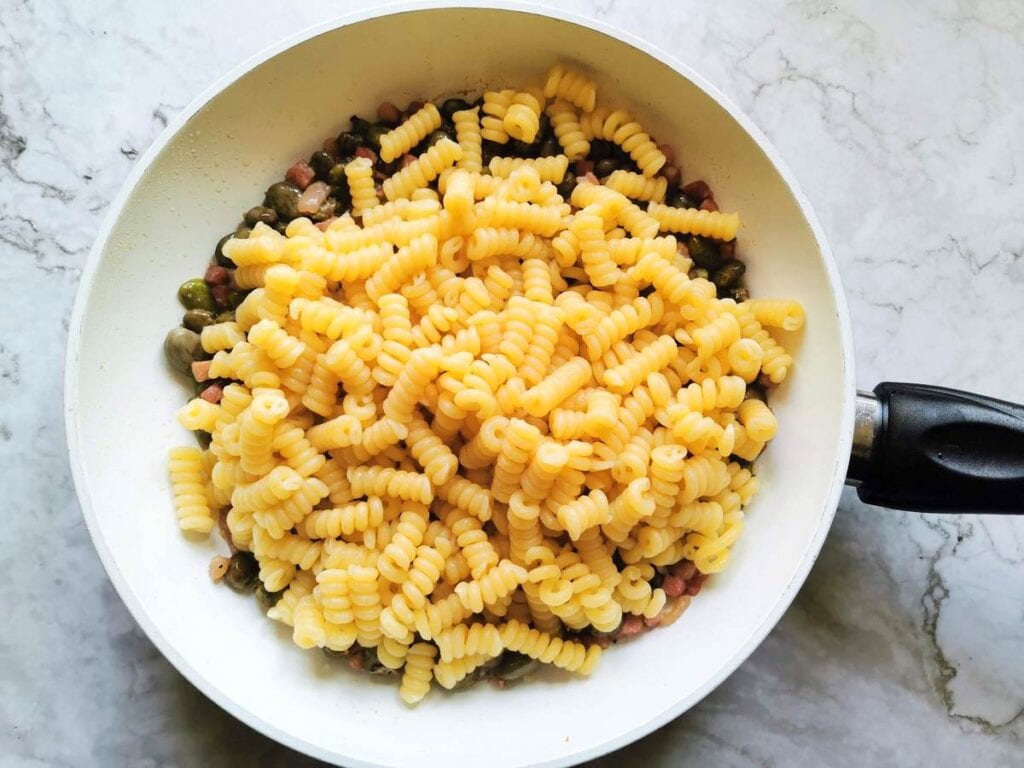 cooked fusilli corte bucati in pan with fava beans sauce