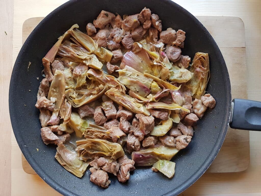 cooked lamb and artichokes in skillet