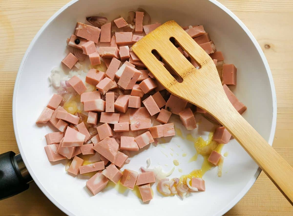 mortadella cubes in pan with shallots