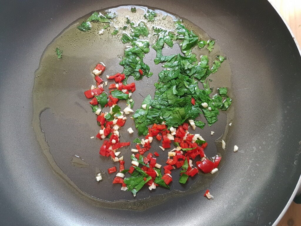 chopped garlic, peperoncino and parsley cooking in skillet