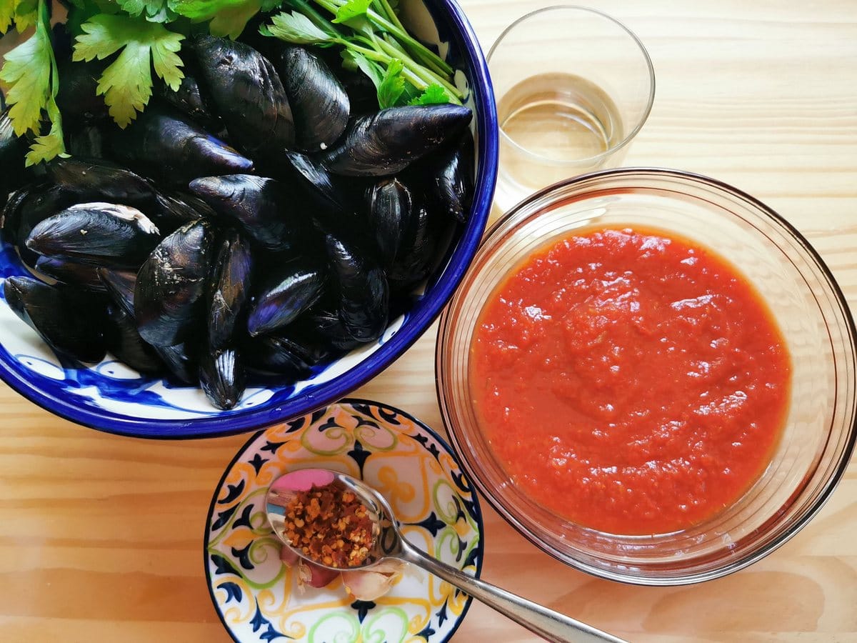 Ingredients for mussels alla tarantina; mussels, fresh parsley, tomato passata, red chili flakes, garlic and white wine.