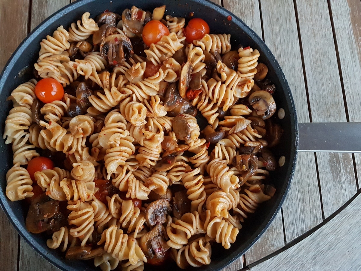 Wholegrain pasta with nduja and mushrooms in a pan.