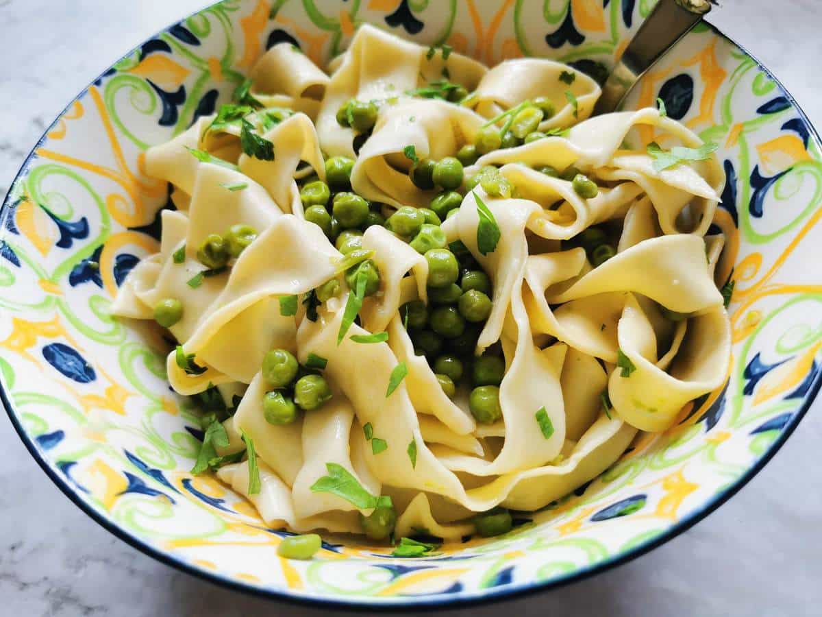 Pasta with peas in colorful bowl.