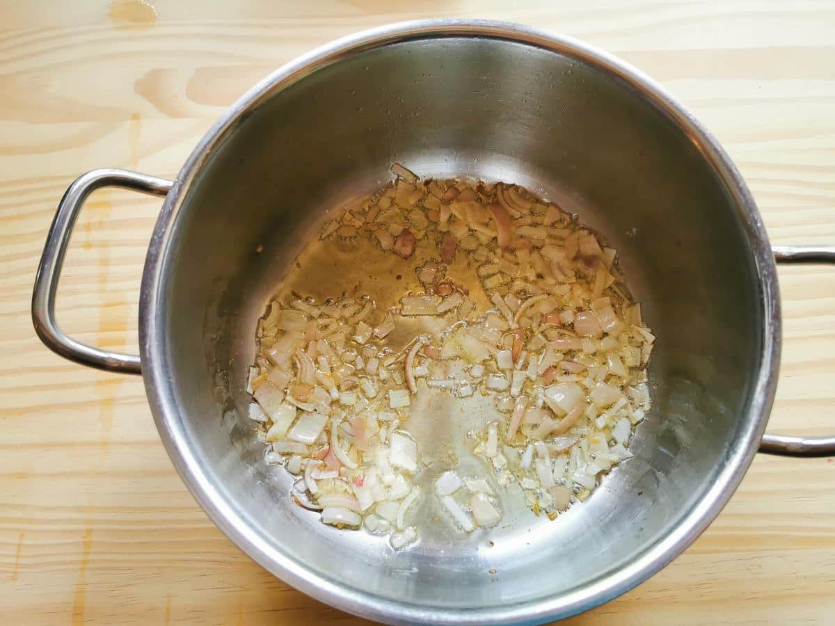 Saluting shallots in a pan.