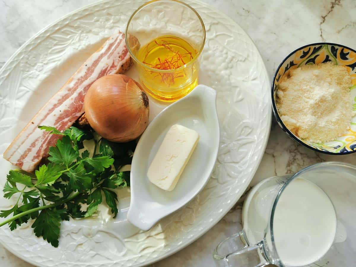 Ingredients to make saffron pasta on a marble counter.