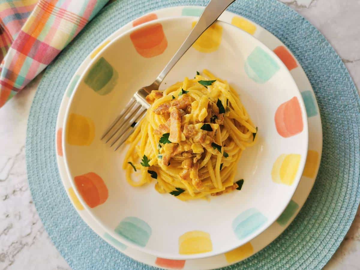 Pasta with saffron in a bowl with a fork.