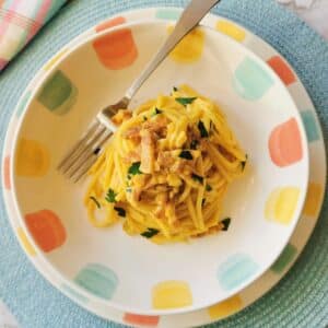 Pasta with saffron in a bowl with a fork.