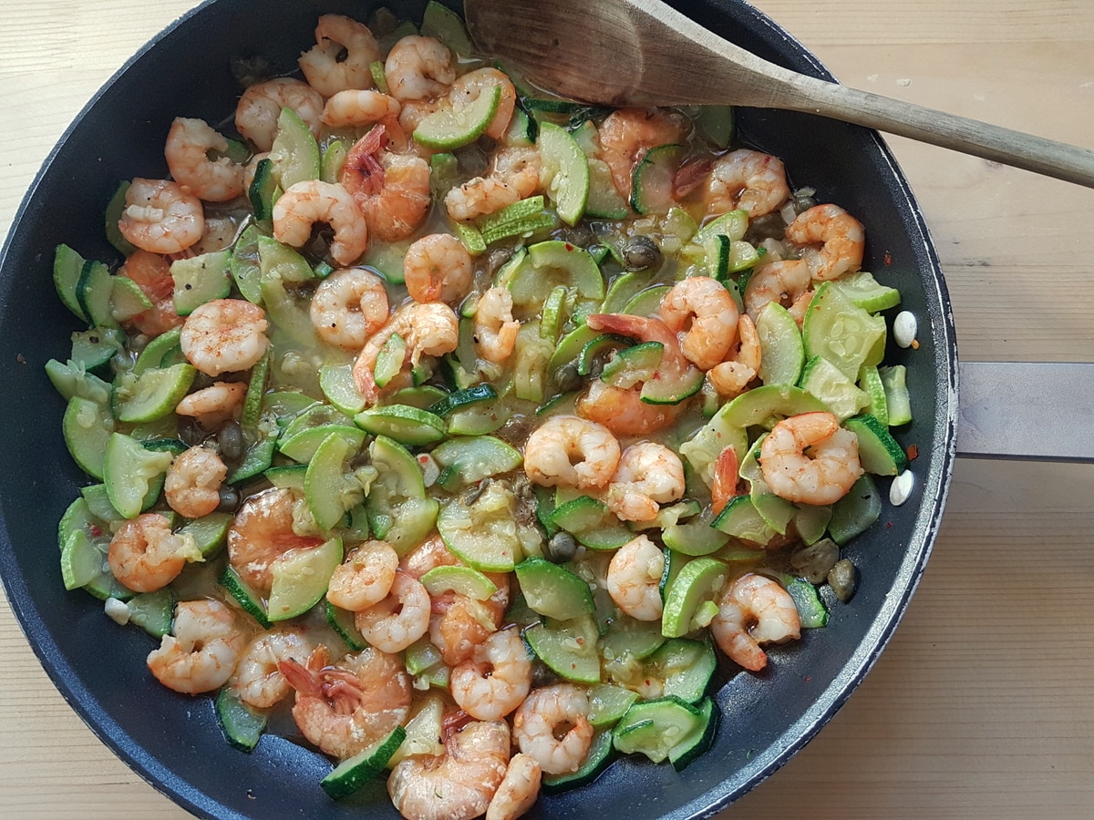 Zucchini and white wine added to the pan of shrimp.