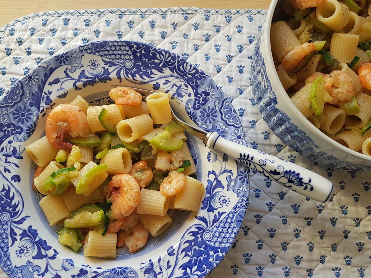 Two bowls of pasta with zucchini and shrimp.
