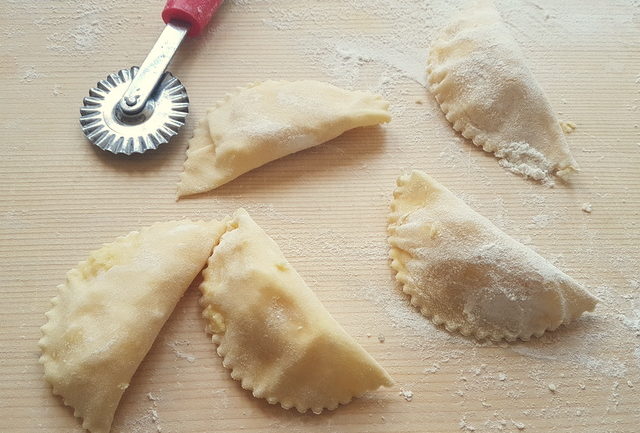 uncooked piconi ravioli on wooden board