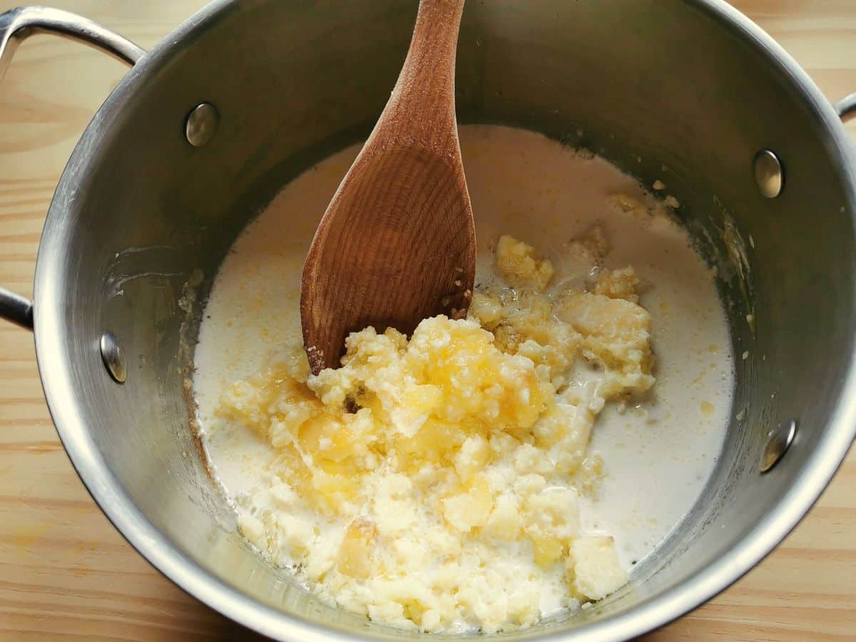 Castelmagno cheese melting in pan with cream and butter.