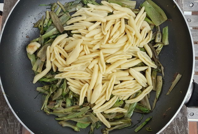 Gekochte Puntarelle und Cavatelli-Nudeln in der Pfanne