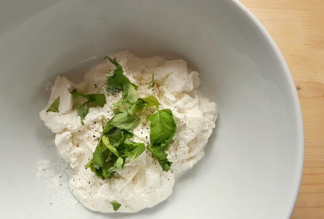 fresh ricotta and basil in white bowl