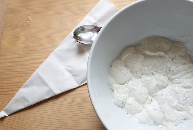 ricotta and basil filling in white bowl with piping bag and teaspoon