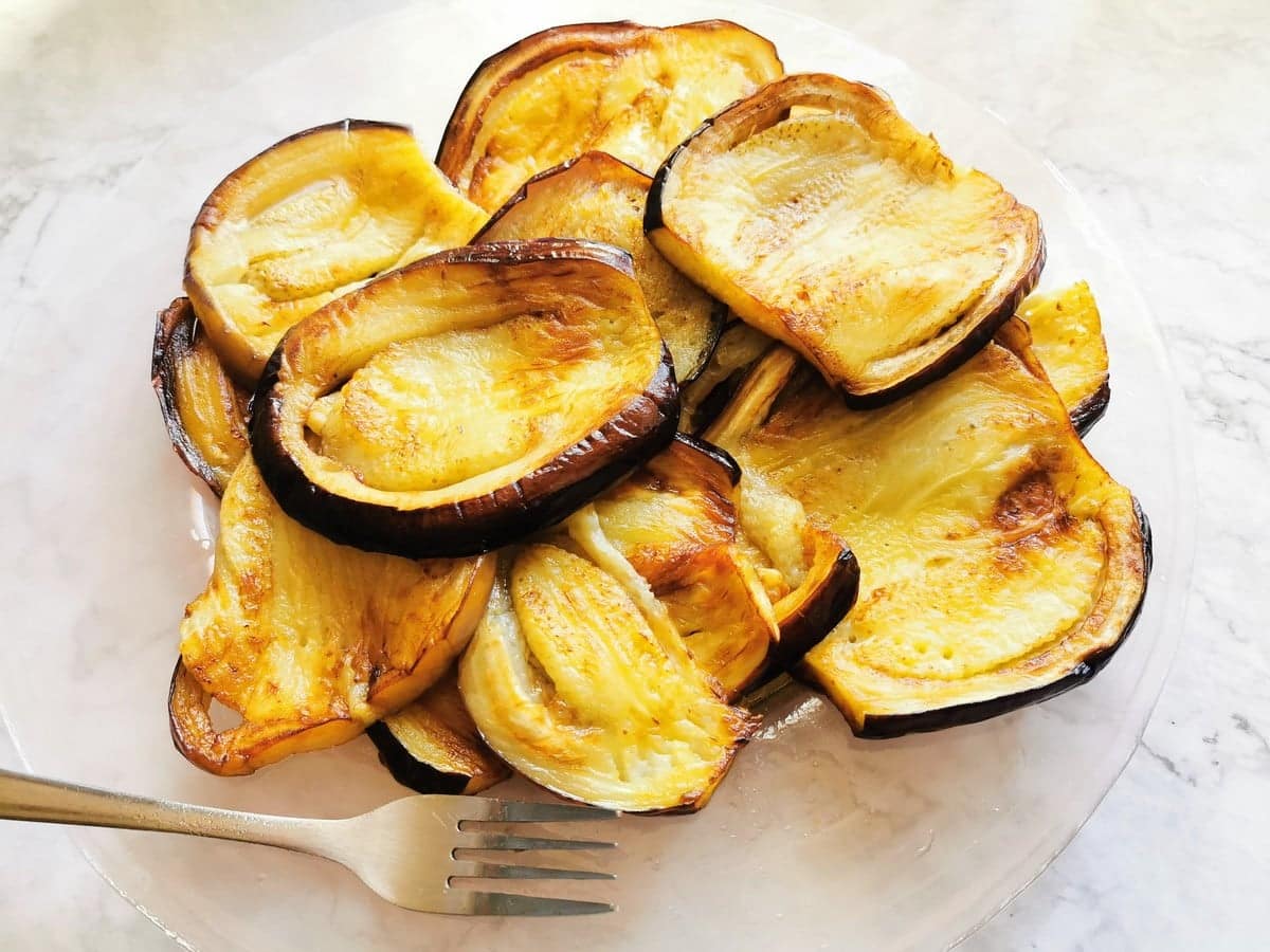 Fried eggplant slices on glass plate.