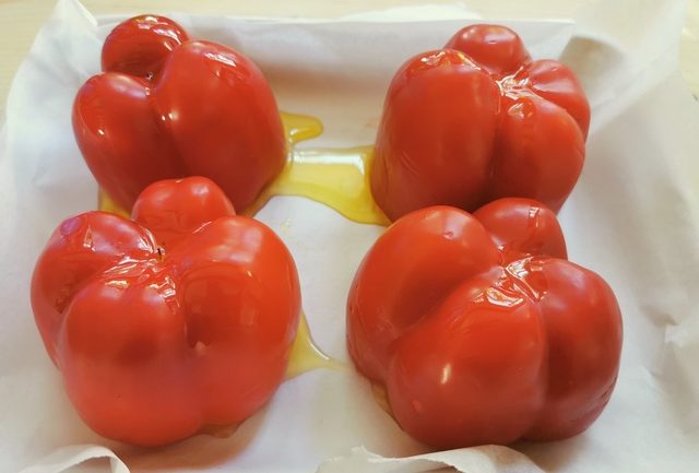 red peppers on baking tray with olive oil