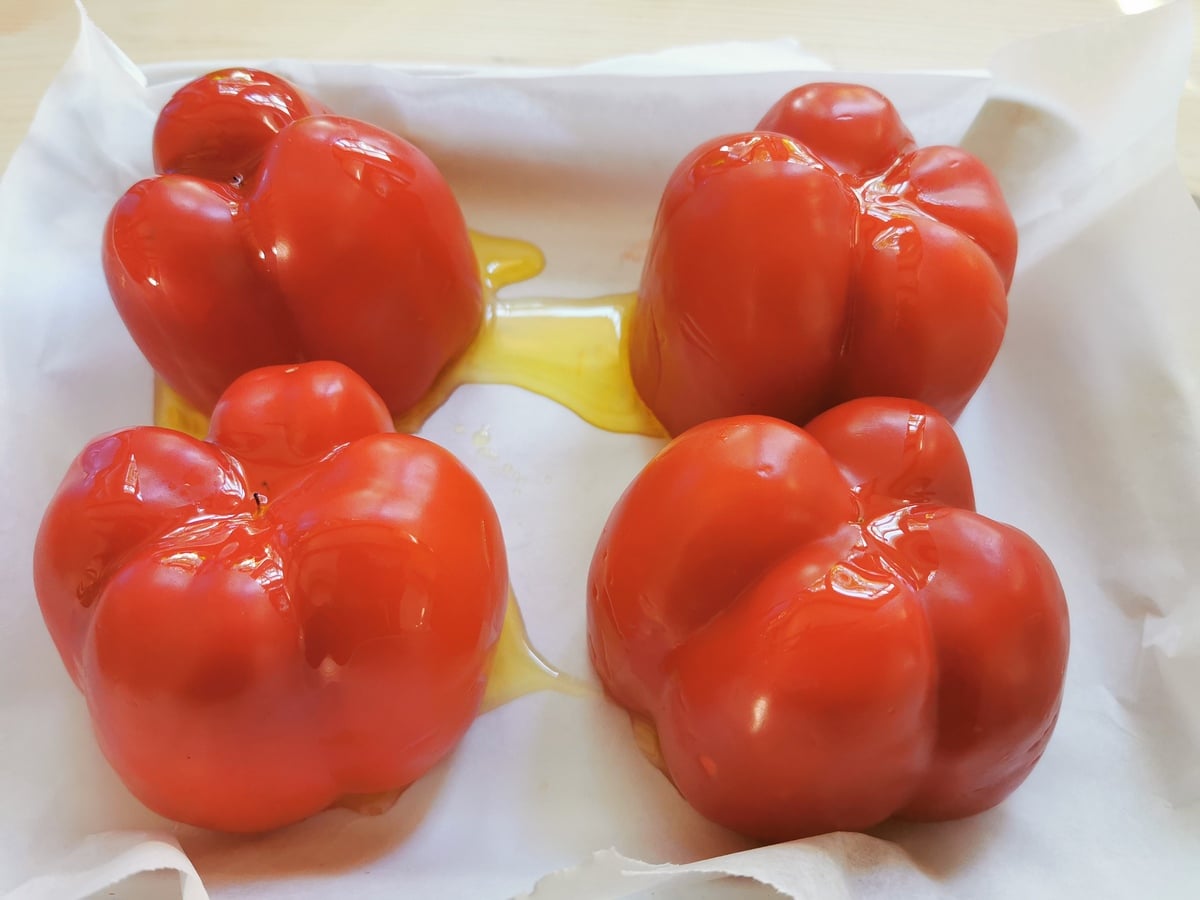 Red bell peppers on a baking tray.