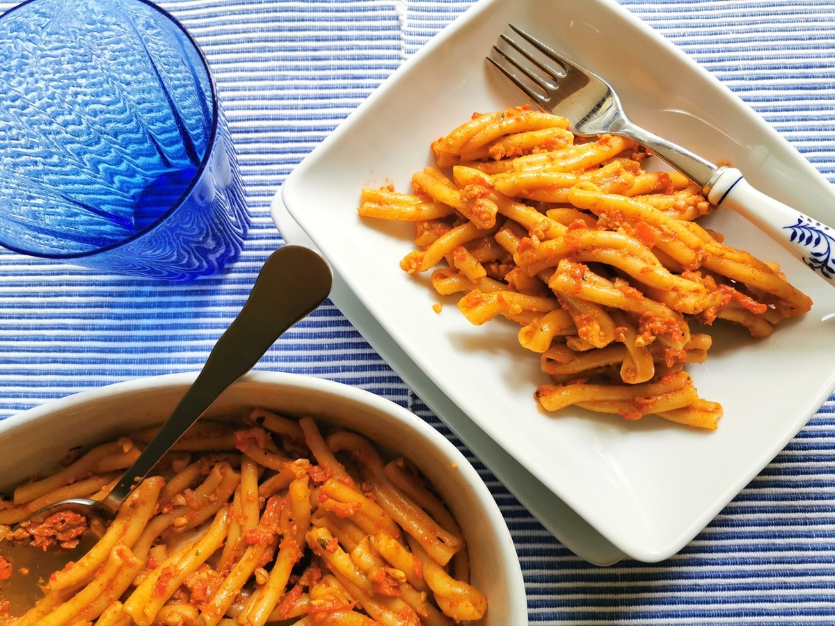 Roasted red pepper pesto with casarecce pasta in a pot and plated in a bowl.