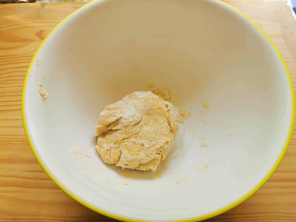 Rough pasta dough ball in large bowl.