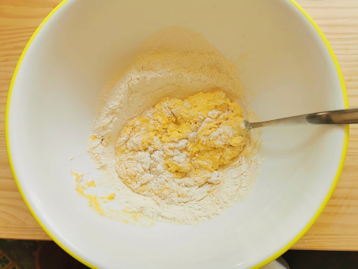 Eggs and flour mixed together with a fork in large bowl.