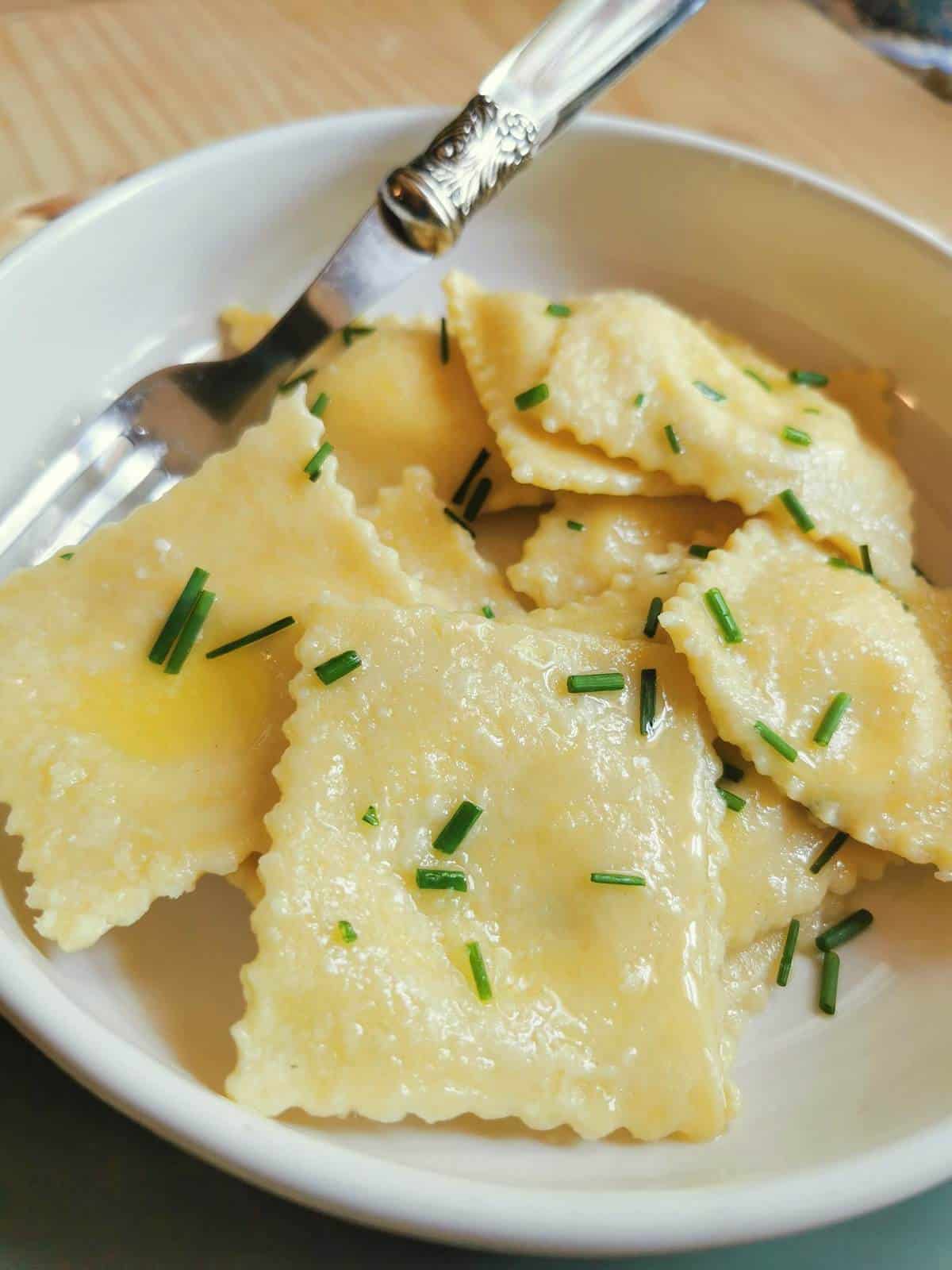 Robiola cheese ravioli in white bowl.