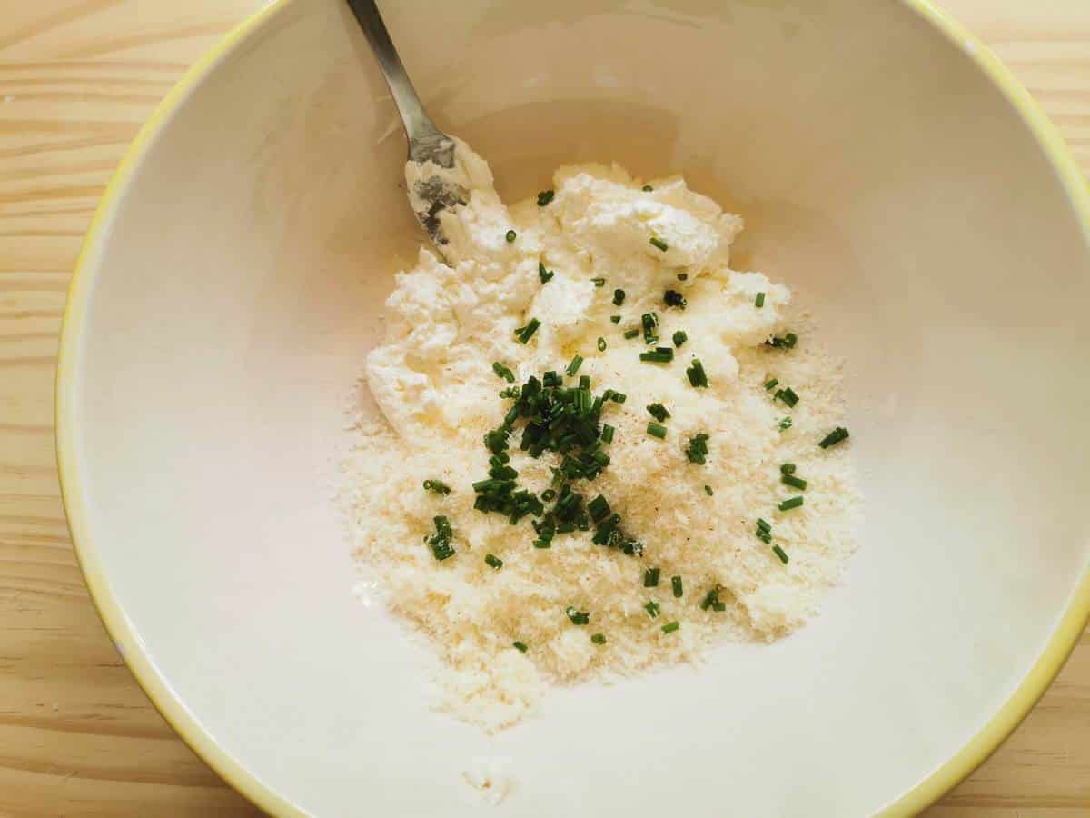 Ingredients for robiola cheese ravioli filling in large white bowl.
