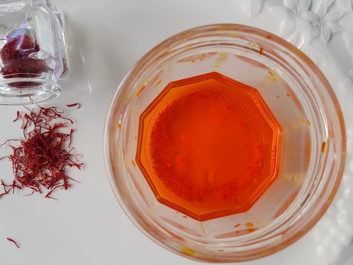 saffron threads soaking in glass of water