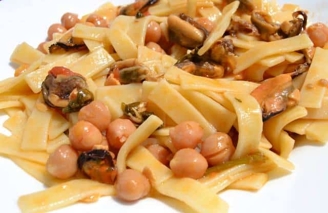 sagne pasta with chickpeas and mussels in white bowl