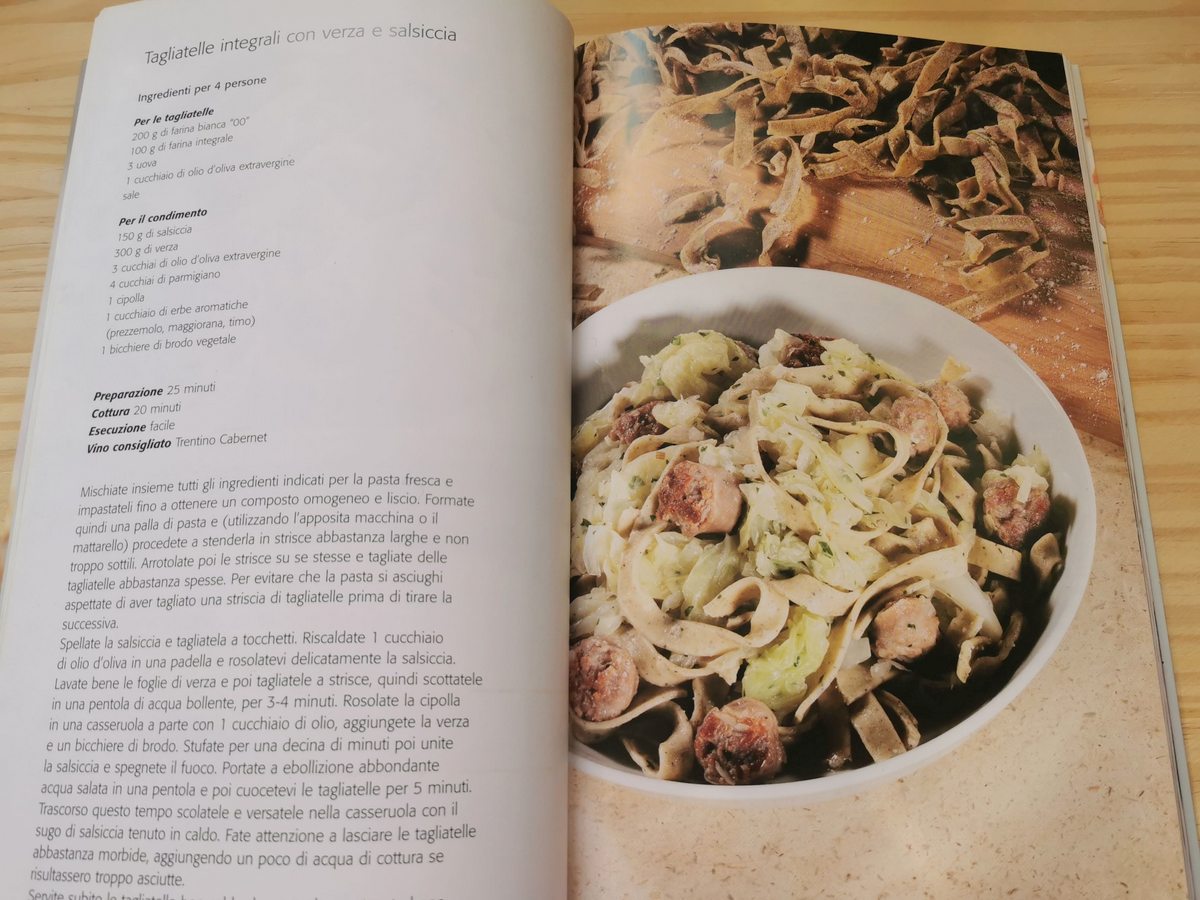 Pages in Italian cookbook with recipe for sausage and cabbage tagliatelle.
