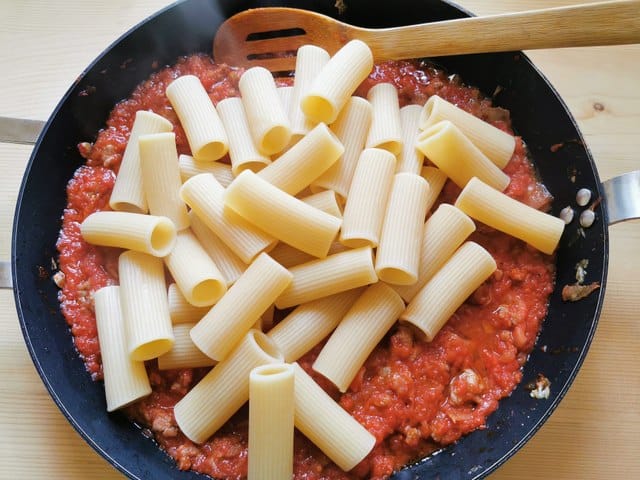 cooked rigatoni added to skillet with alla zozzona sauce