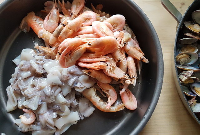 shrimps and calamari ready to cook in frying pan