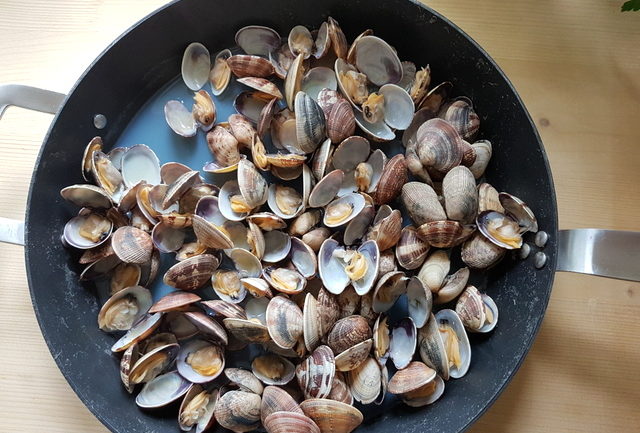 clams cooking in large pan