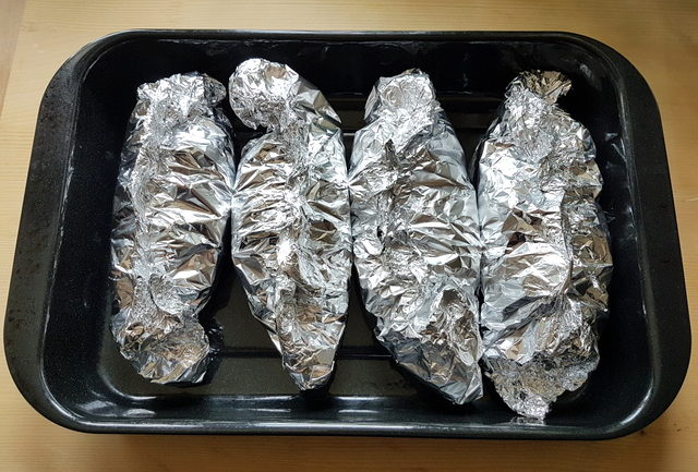 4 portions of seafood linguine al cartoccio wrapped in foil