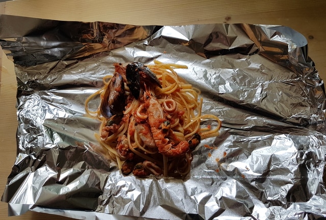 one portion of seafood linguine al cartoccio on foil