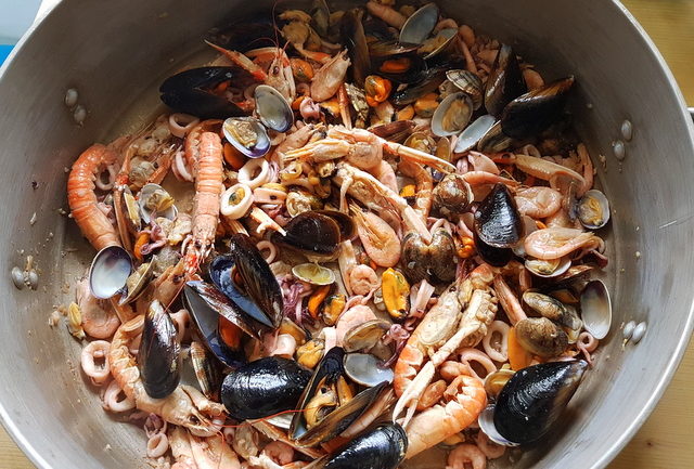 Mussels, clams, scampi, shrimps and calamari cooking in large pot