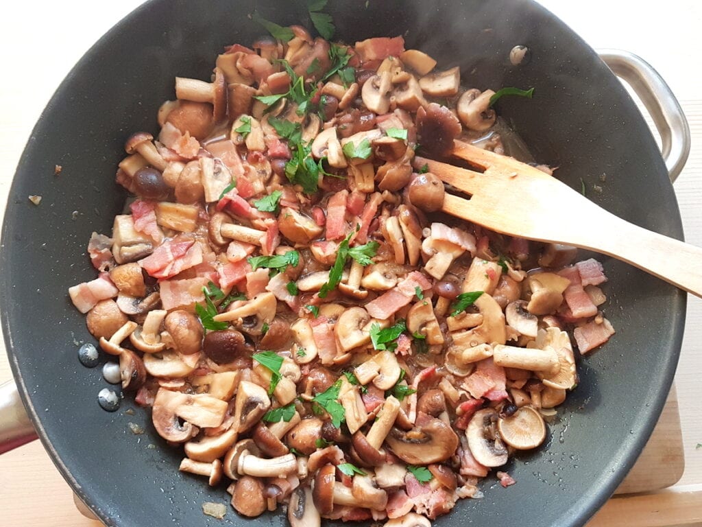 mushrooms, pancetta, onions and parsley cooking in skillet